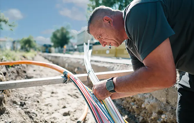 Menner Tiefbau Mitarbeiter bei der Glasfaserkabelmontage